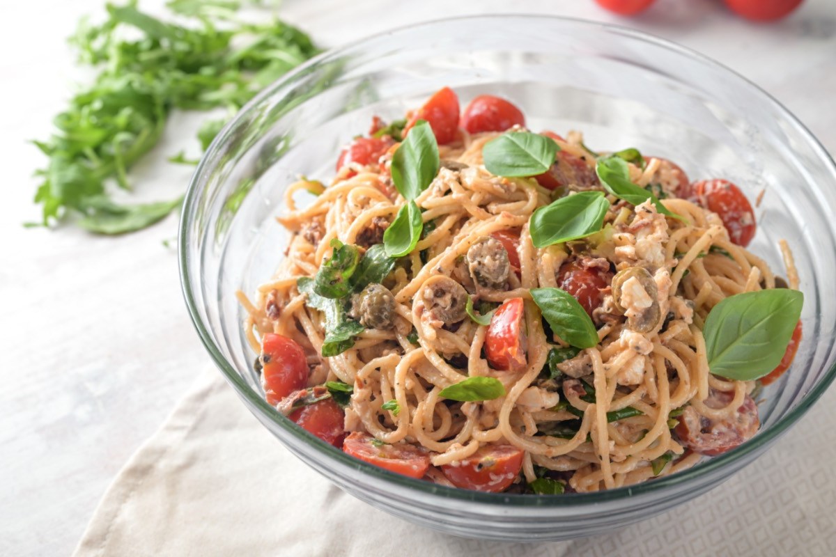 Ein Schüssel Spaghettisalat mit cremigem Dressing in der Draufsicht.