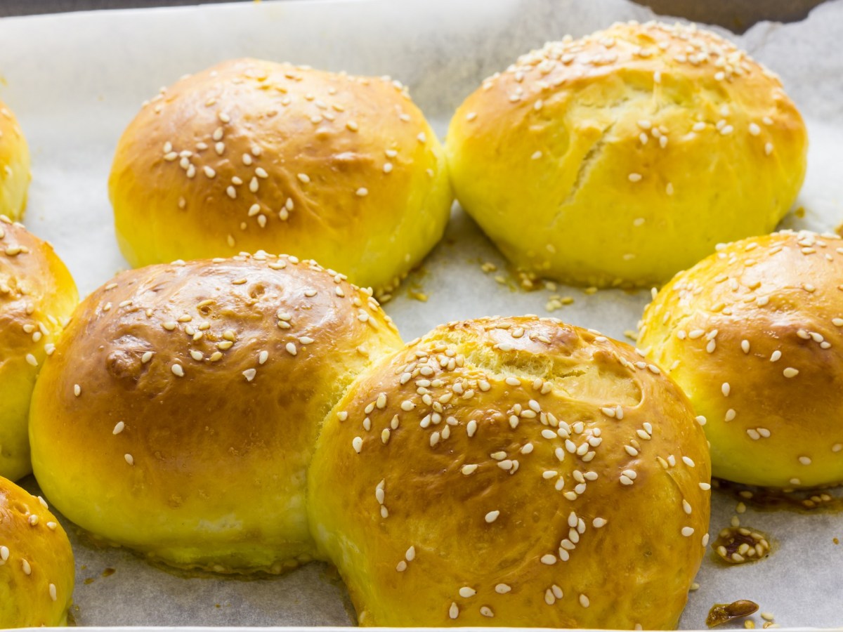 Backblech mit mehreren selbst gemachten Süßkartoffelbrötchen mit Sesam