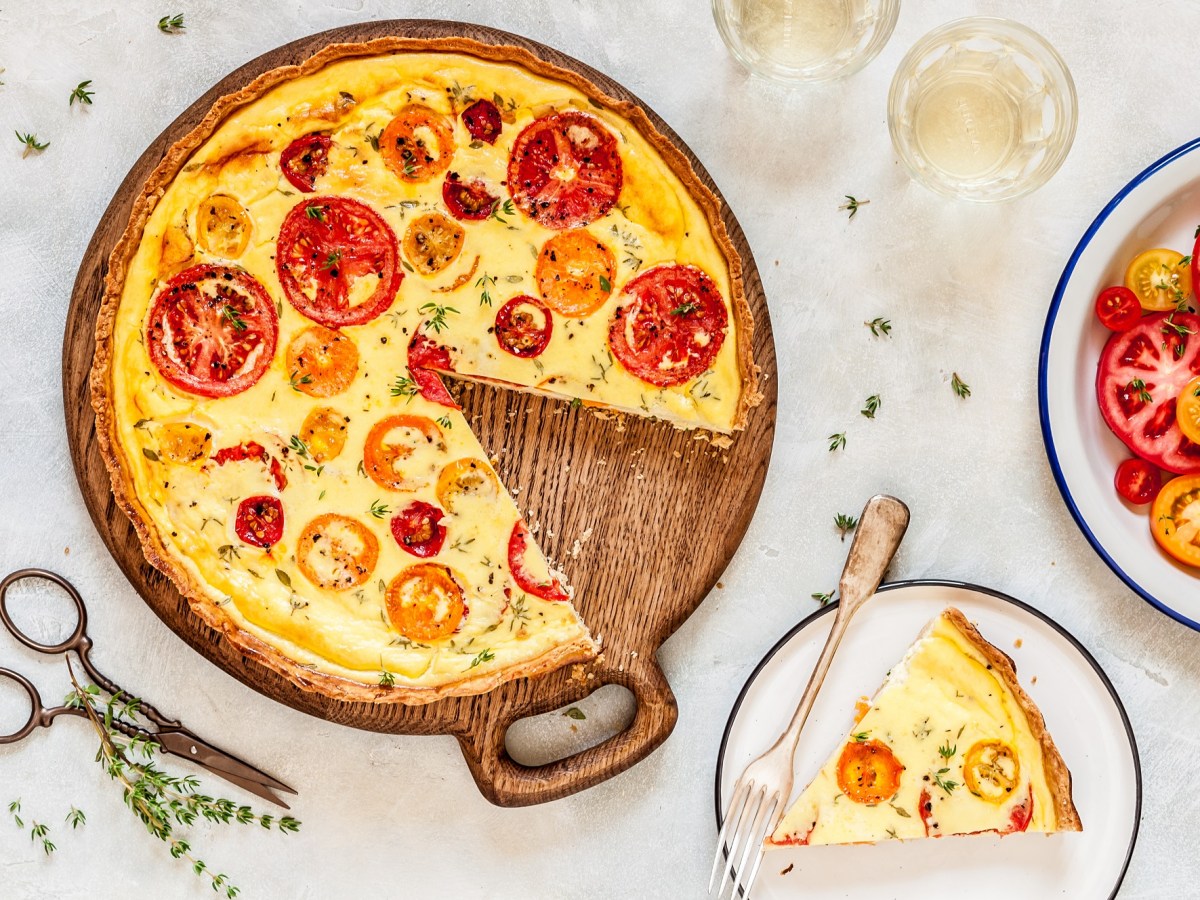 Eine angeschnittene Tomaten-Ricotta-Quiche in der Draufsicht.