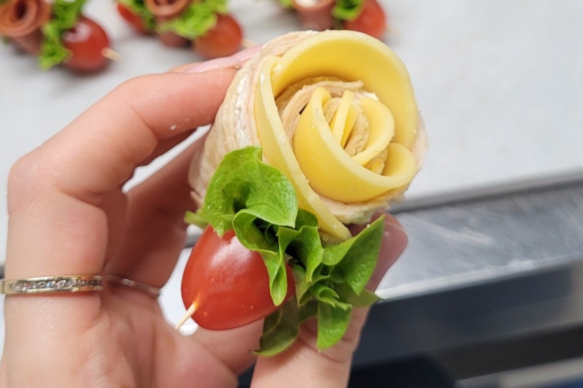 Eine Frau hält eine Tortilla-Rose in der Hand.