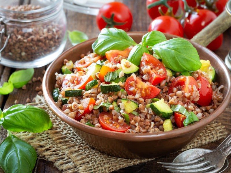 Buchweizensalat mit Zucchini und Tomaten in einer Schüssel.