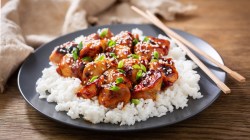 Chicken-Teryaki auf schwarzem Teller und Stäbchen