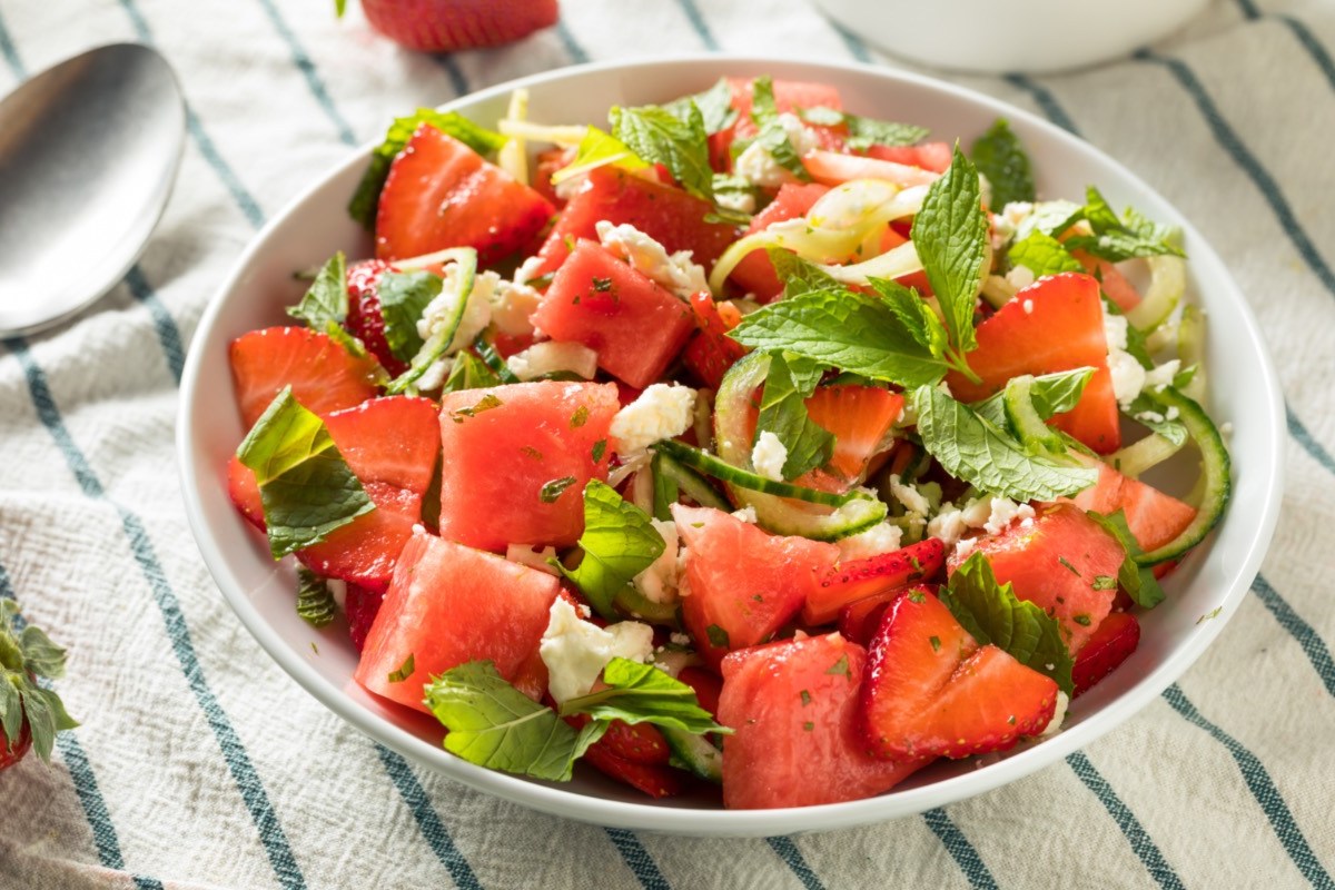 Ein Erdbeer-Melonen-Salat mit Feta in einer flachen Schale.