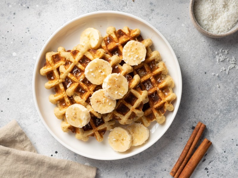 French-Toast-Waffeln auf weißem Teller mit Zimtstangen