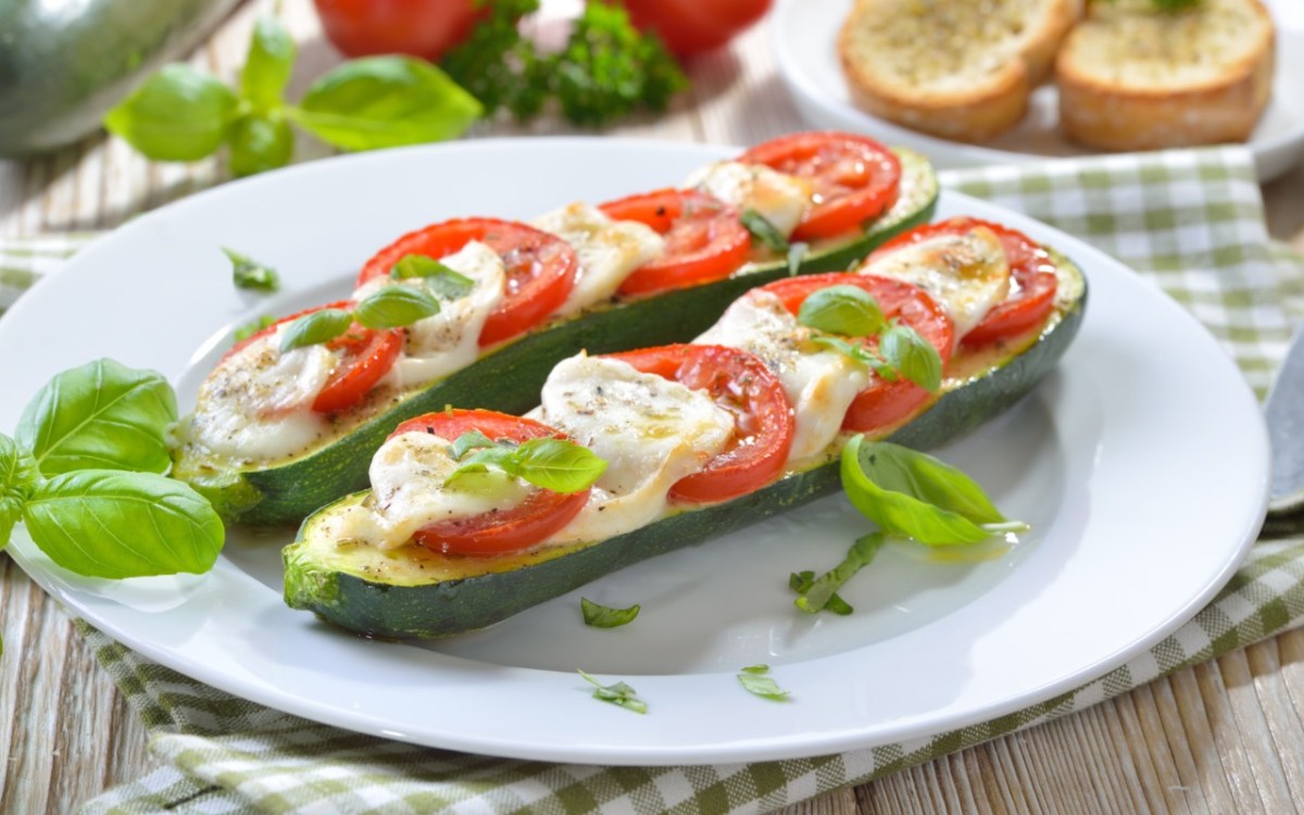 Zwei gegrillte Zucchini mit Tomate-Mozzarella und Basilikum.