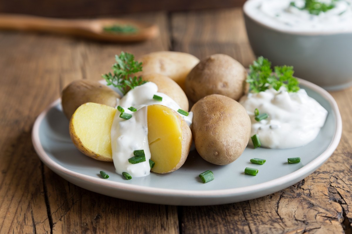 Ein Teller Pellkartoffeln mit Quark, dazu passt und Gurkensalat.