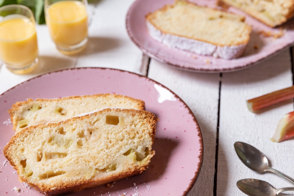 Zwei Stücke Rhabarber-Kastenkuchen auf einem rosa Teller.