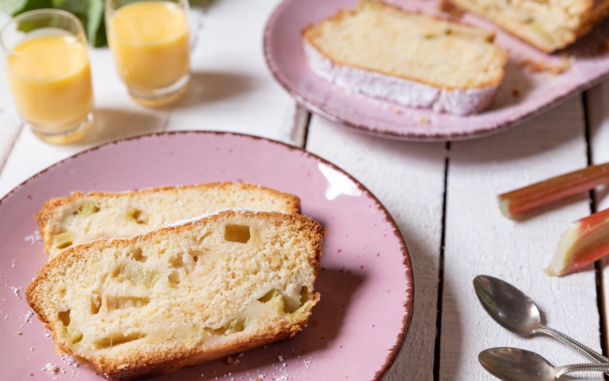 Zwei Stücke Rhabarber-Kastenkuchen auf einem rosa Teller.