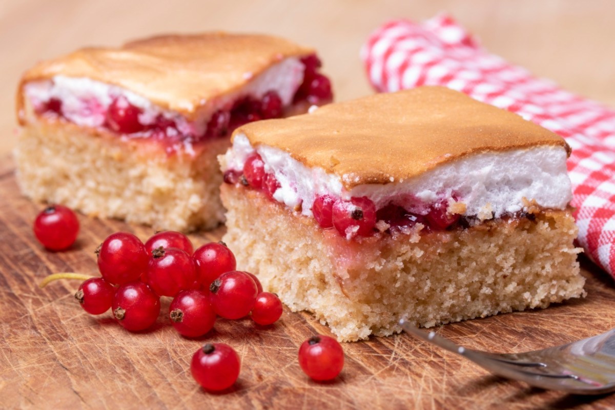 Zwei StÃ¼cke Ribiselkuchen. Daneben frische Johannisbeeren.