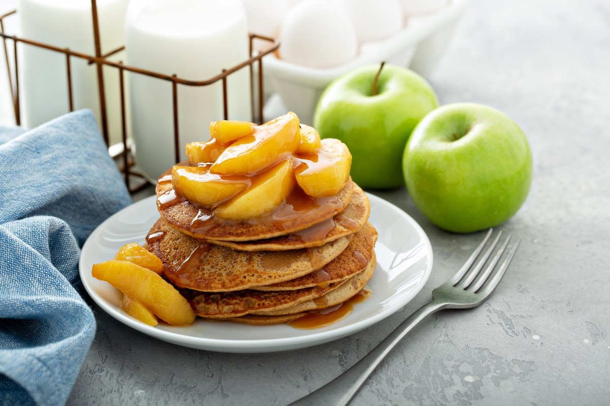 Teller mit Zwieback-Pancakes und Apfel-Topping, Gabel daneben