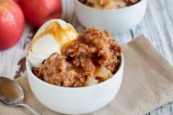 Eine Schüssel Apple-Crisp mit Vanilleeis und Karamellsoße.