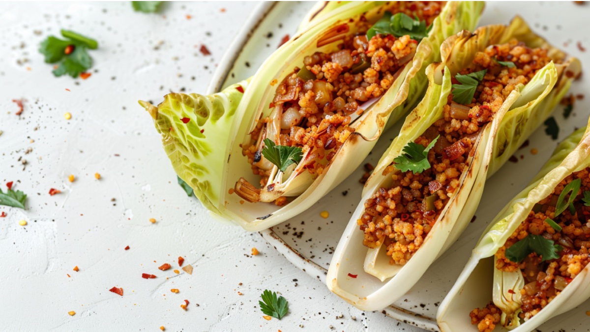 Chicoree-Tacos mit Couscous-Füllung auf hellem Hintergrund.