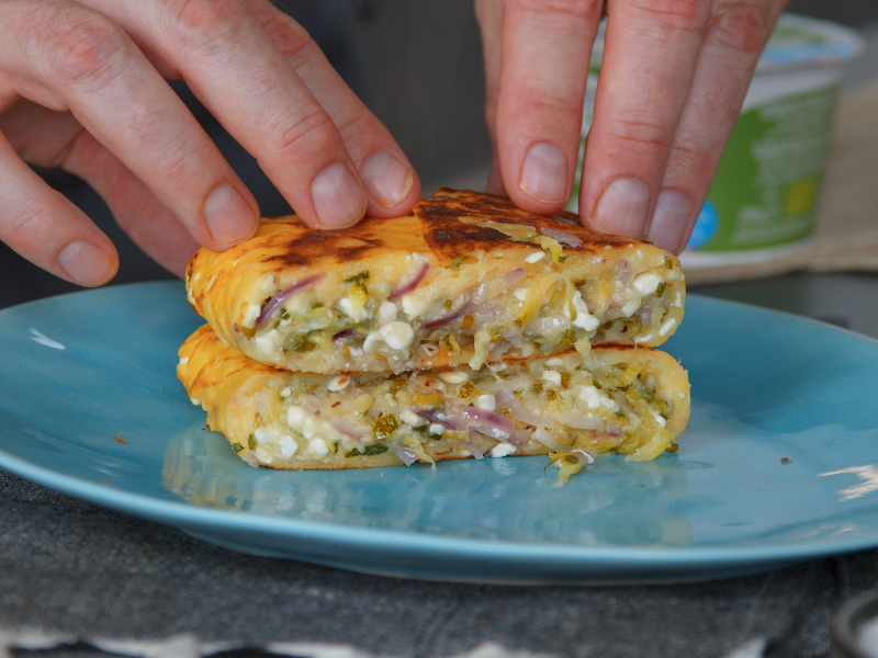 Hüttenkäse-Tasche mit Zucchini-Füllung auf blauem Teller