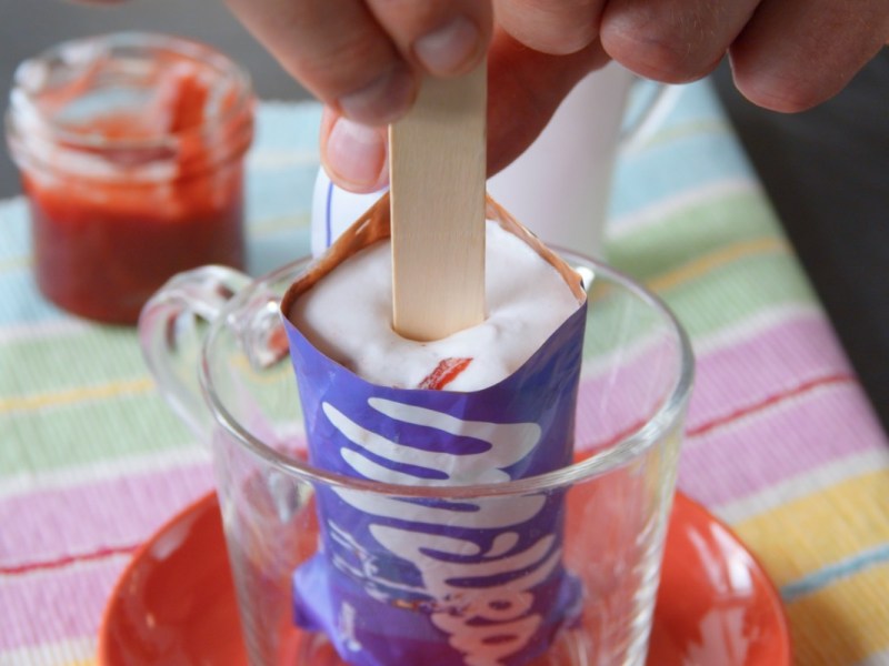 Ein Milka-Eis am Stiel in einer Schüssel, in das ein Holzstiel gesteckt wird.