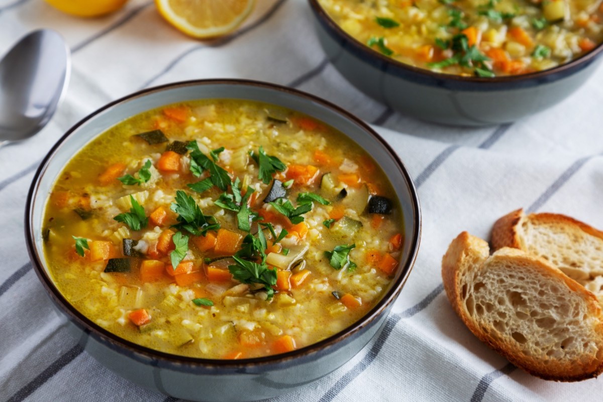 Eine Schüssel Reissuppe. Daneben liegen 2 Stücke Brot.