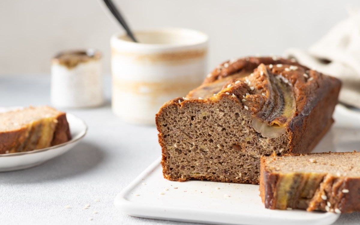 Ein aufgeschnittenes Tahini-Bananenbrot auf einem Brett.