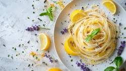 Zironen-Lavendel-Tagliatelle auf hellem Teller und hellem Tisch.