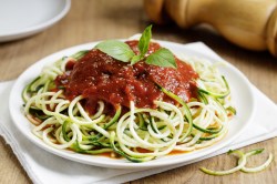 Teller mit Zucchininudeln mit Tomatensoße