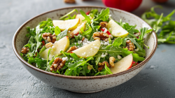 Eine Schale Apfel-Rucola-Salat mit Walnüssen und Parmesan.