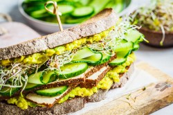 Ein Avocado-Tofu-Sandwich auf einem Brett