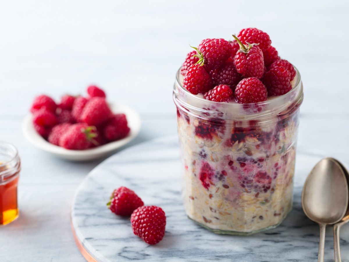 Bircher Müsli mit Himbeeren in einem Marmeladenglas.