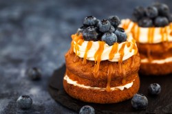 2 Cupcake-Sandwiches mit Heidelbeeren und Karamellsoße verziert.