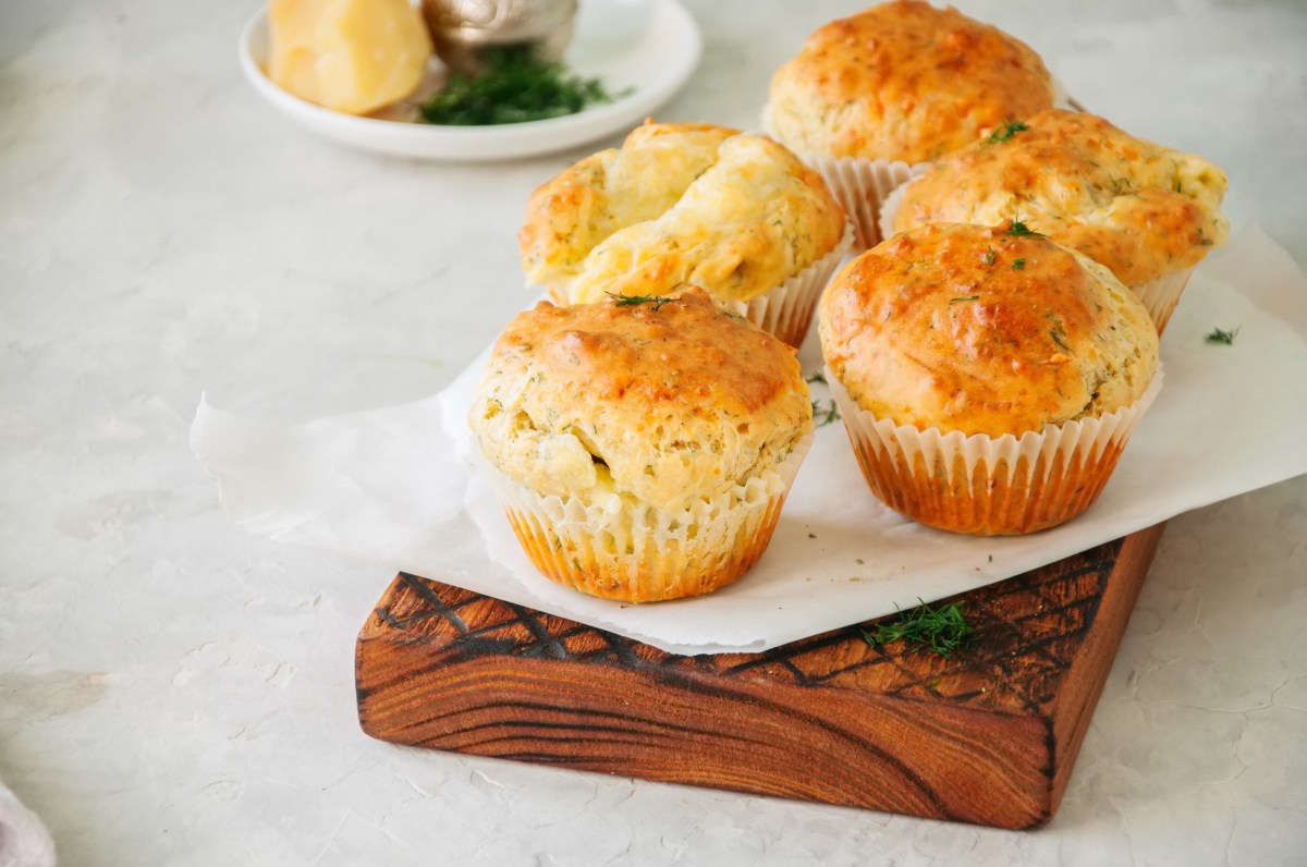 Hüttenkäse-Muffins mit Zucchini auf einer weißen Papierunterlage.