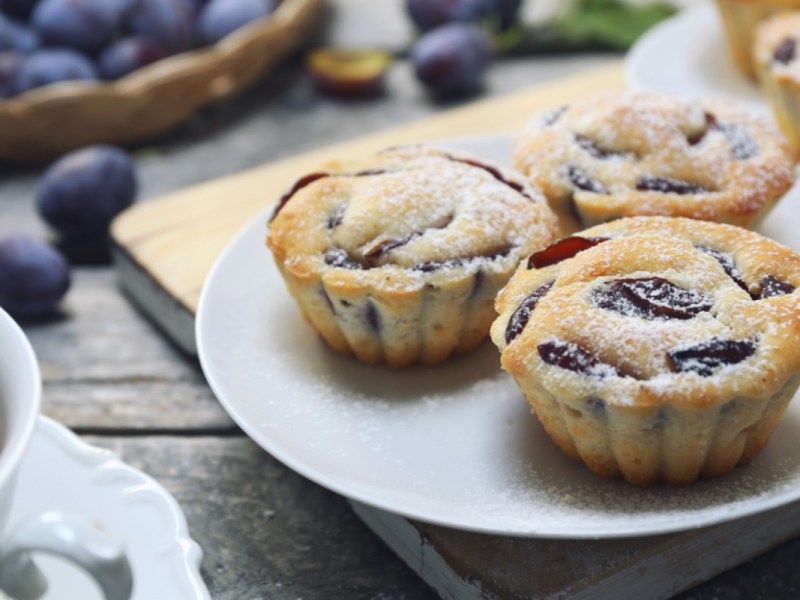 Drei Pflaumenmuffins auf einem Teller.