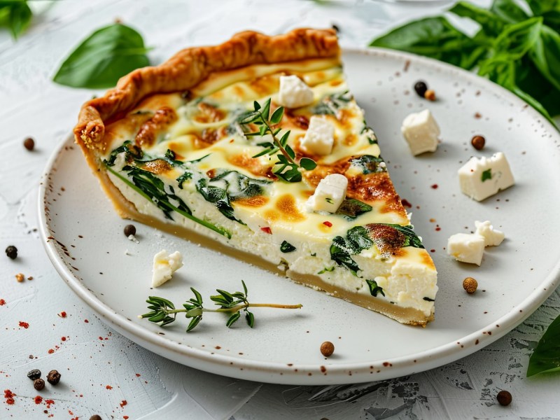 Ein Stück Feta-Spinat-Quiche auf einem Teller