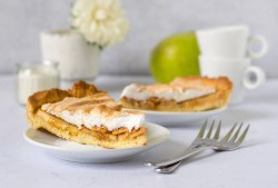 Ein Stück Apfelkuchen mit Baiser auf einem Teller.