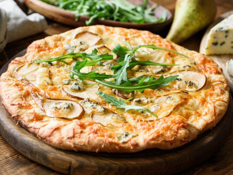 Eine Pizza mit Birne und Blauschimmelkäse und Rucola