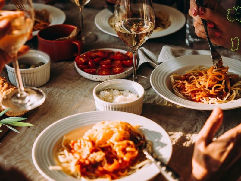 Italienische Küche: Eine Gruppe Menschen an einem Tisch mit italienischem Essen.