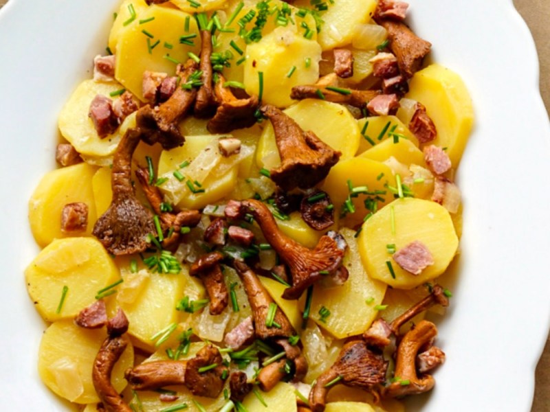 Ein Kartoffel-Pfifferling-Salat auf einem Teller in der Draufsicht.