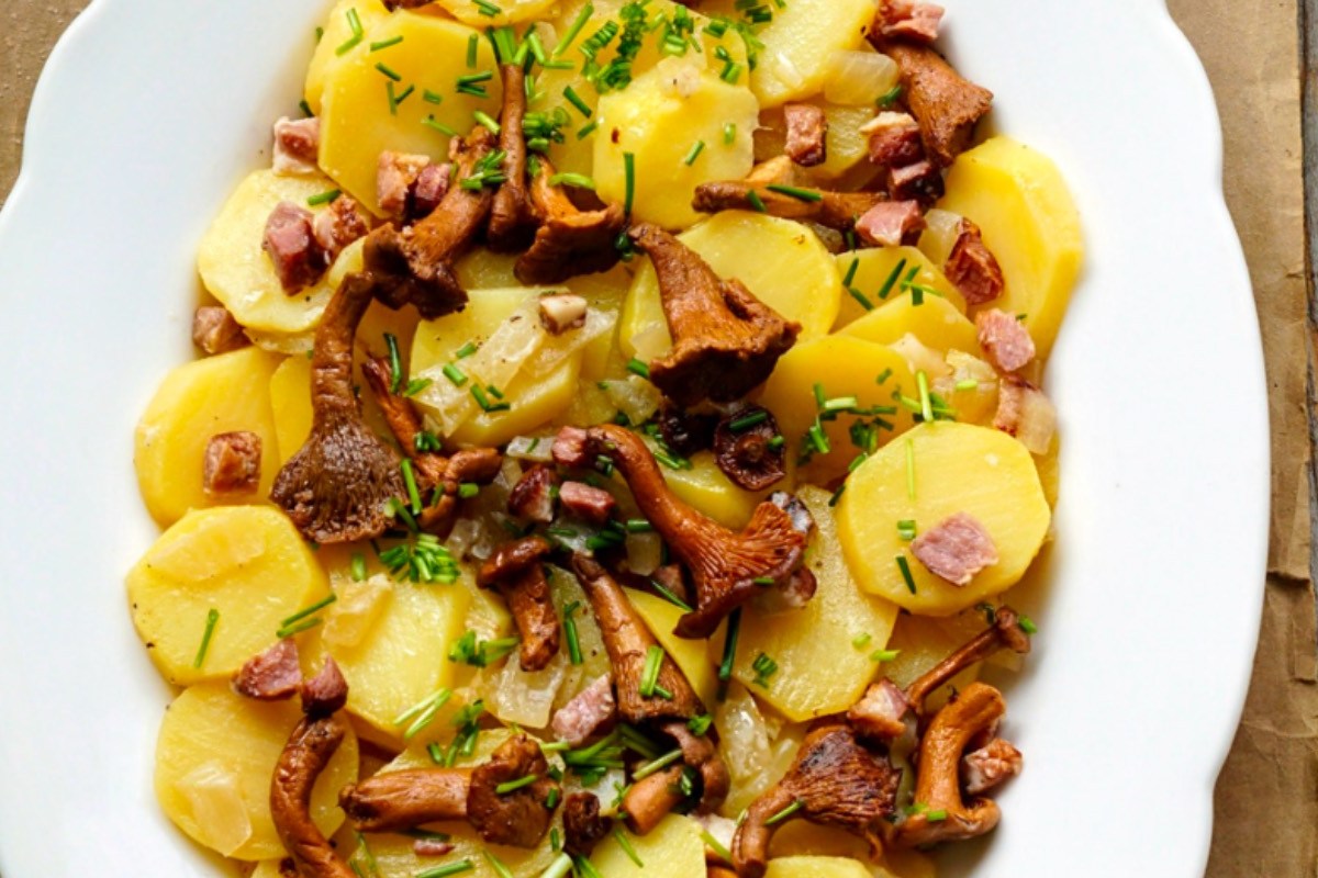 Ein Kartoffel-Pfifferling-Salat auf einem Teller in der Draufsicht.