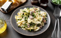 Ein Teller mit Pasta à la Chef. Daneben liegen Besteck und Zutaten.