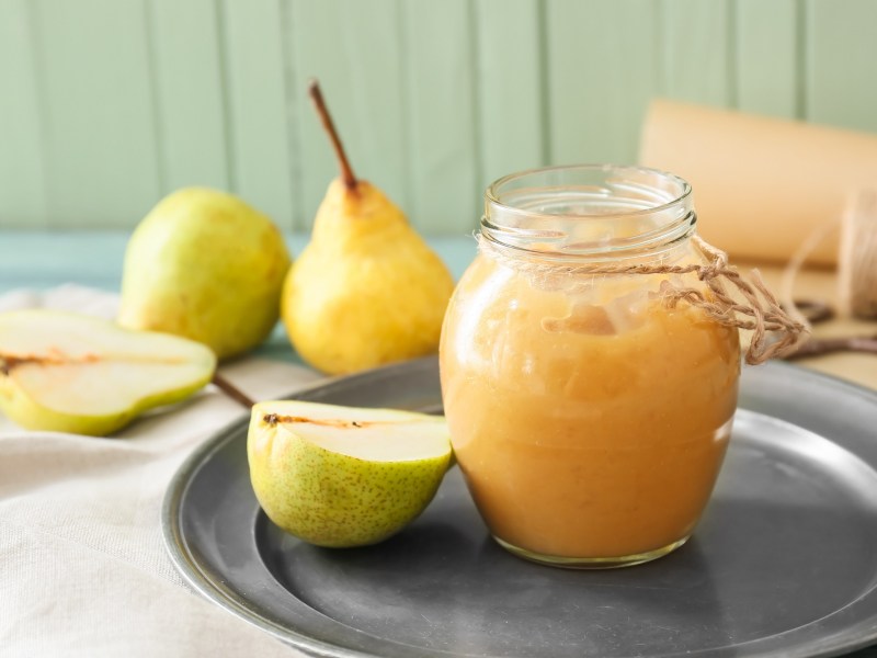 Ein Glas Birnen-Ingwer-Marmelade auf einem Silbertablett.