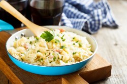 Hackfleisch-Kohl-Pfanne mit Nudeln mit Kochlöffel aus Holz.