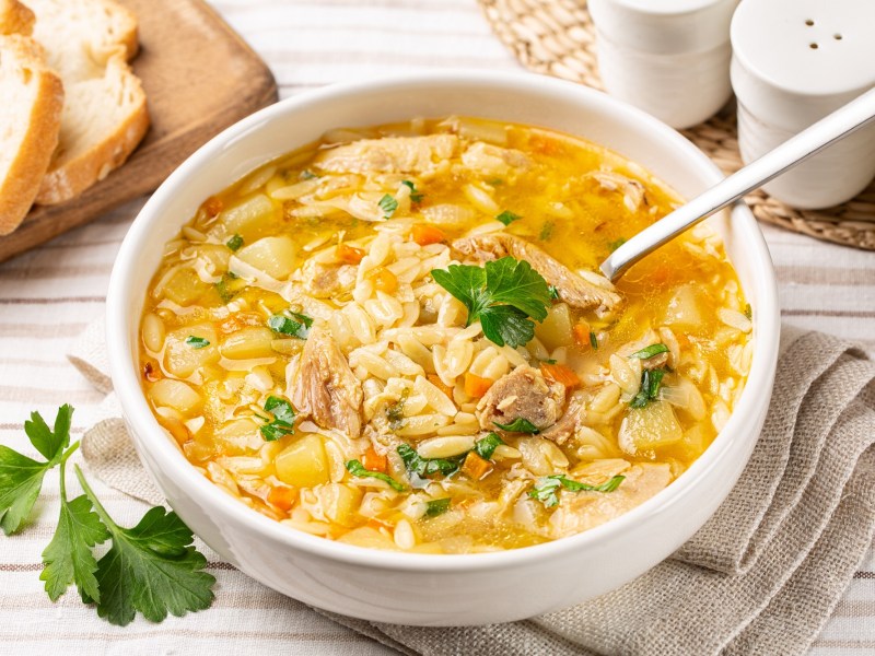 Hühnersuppe mit Orzo in einer Schüssel.