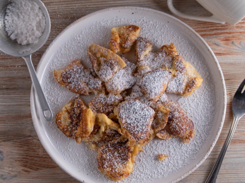 Kaiserschmarrn aus dem Airfryer mit Puderzucker auf einem Teller.