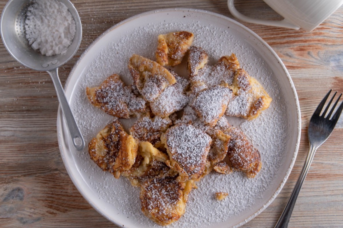 Kaiserschmarrn aus dem Airfryer mit Puderzucker auf einem Teller.