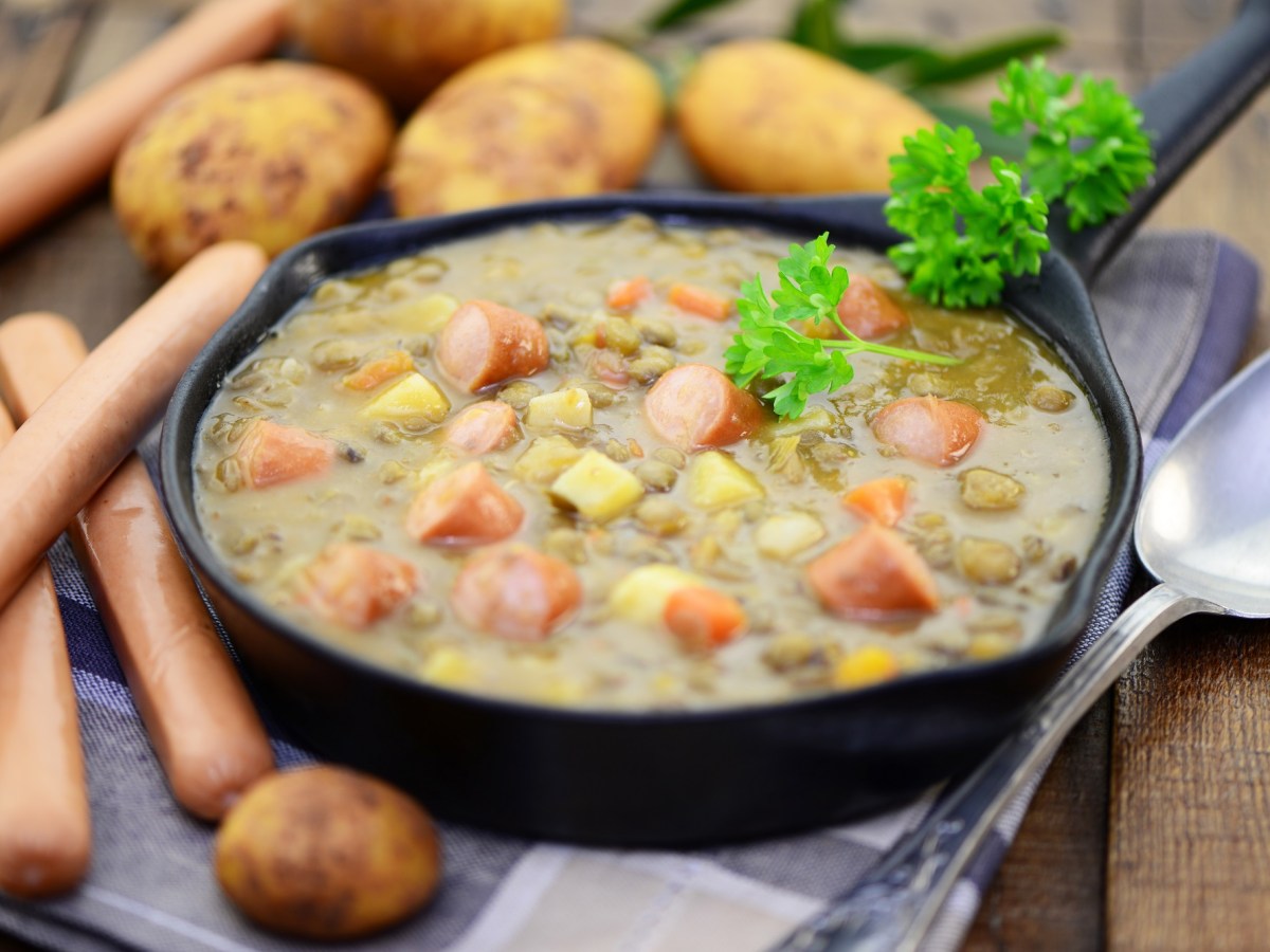 Eine Portion Kartoffelsuppe mit Würstchen.