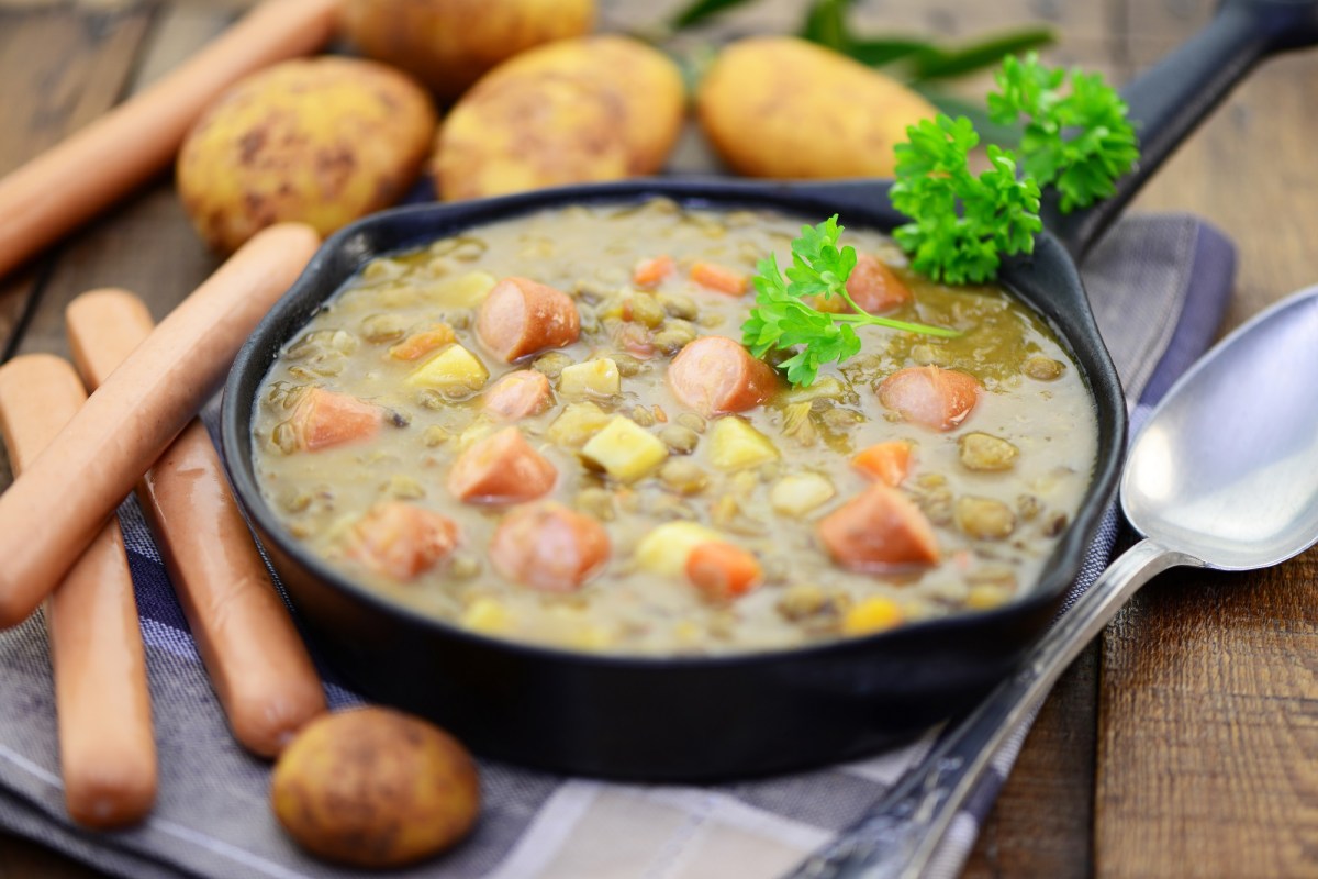 Eine Portion Kartoffelsuppe mit Würstchen.