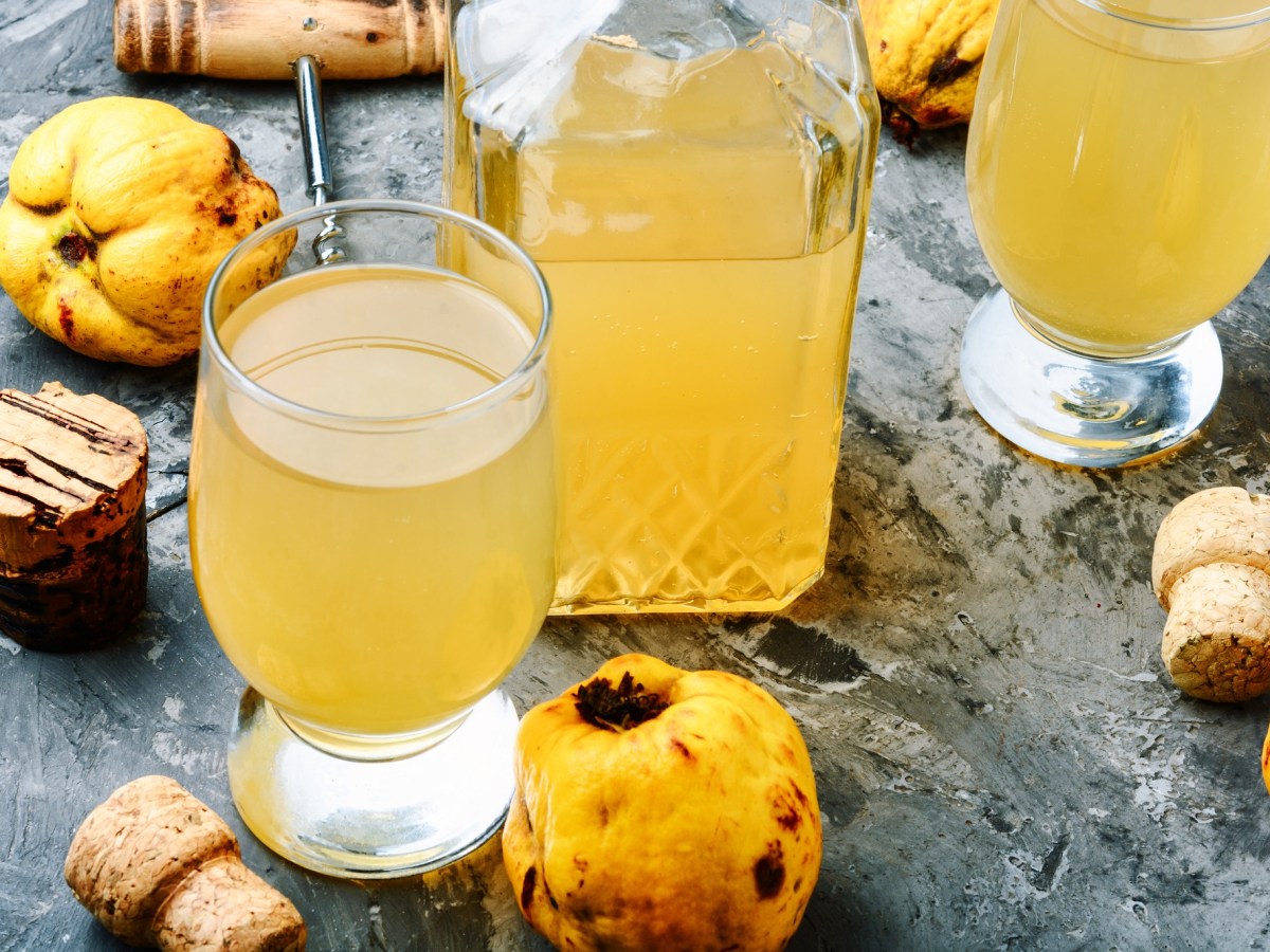 Eine Flasche und zwei Gläser mit Quittensaft