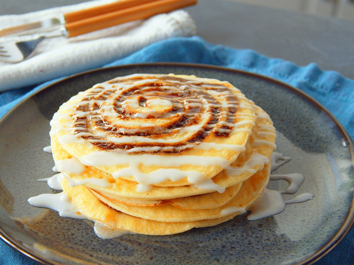 Zimtschnecken-Pancakes mit Glasur auf einem Teller.