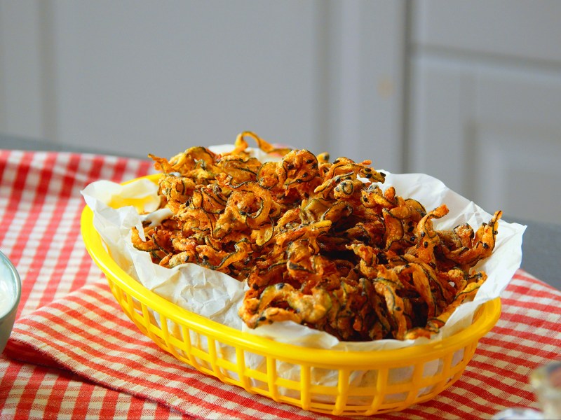 Zucchini-Curly-Fries in einem gelben Körbchen.