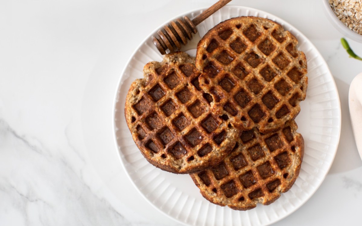 Drei Apfel-MÃ¼sli-Waffeln auf einem Teller in der Draufsicht.