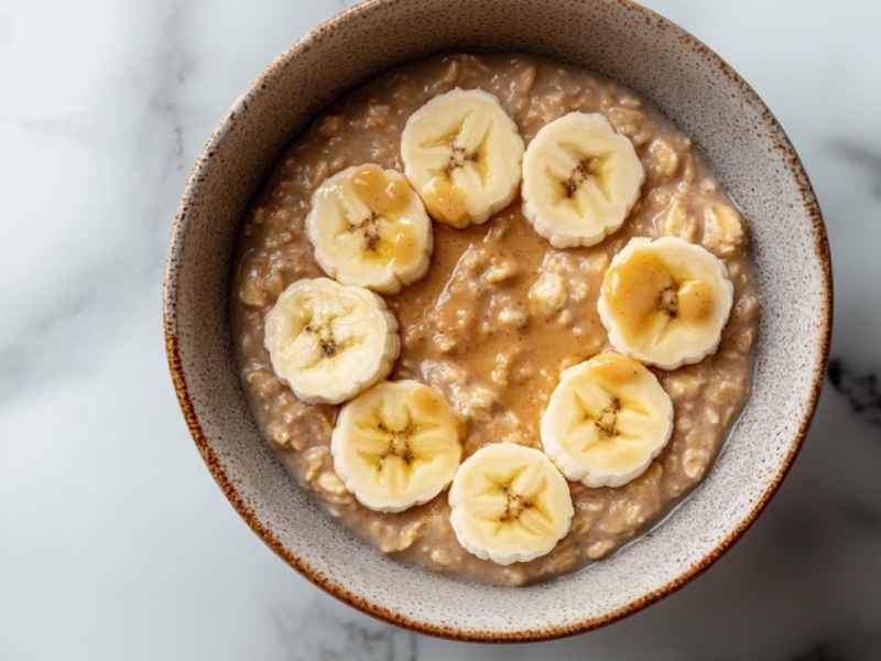 Eine Schale Overnight Oats mit Banane und Erdnussbutter in der Draufsicht.