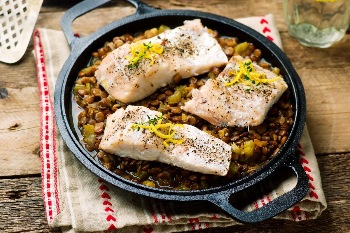 Ein paar Fischfilets mit Linsengemüse.