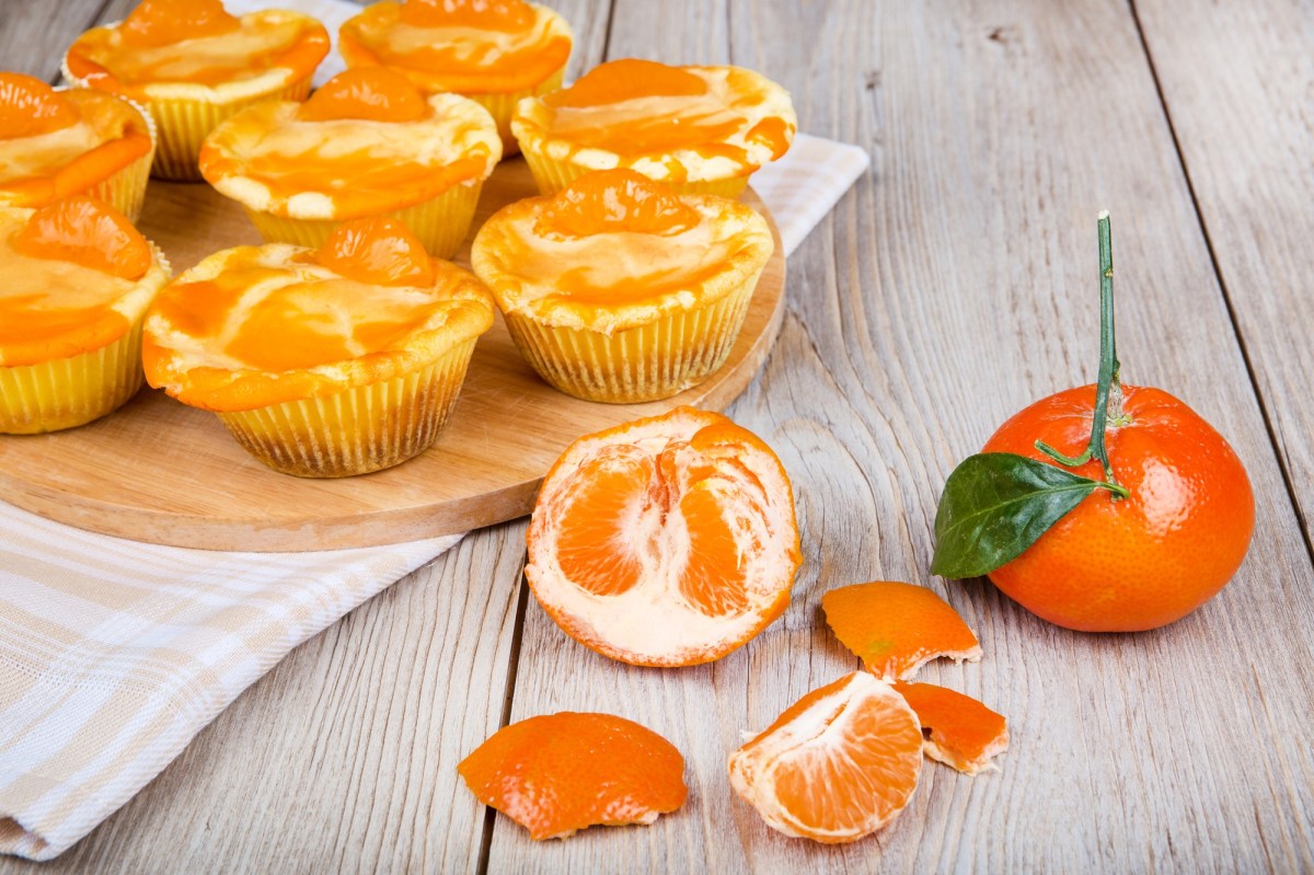 KÃ¤sekuchen-Muffins aus der HeiÃŸluftfritteuse, davor eine frische Mandarine.