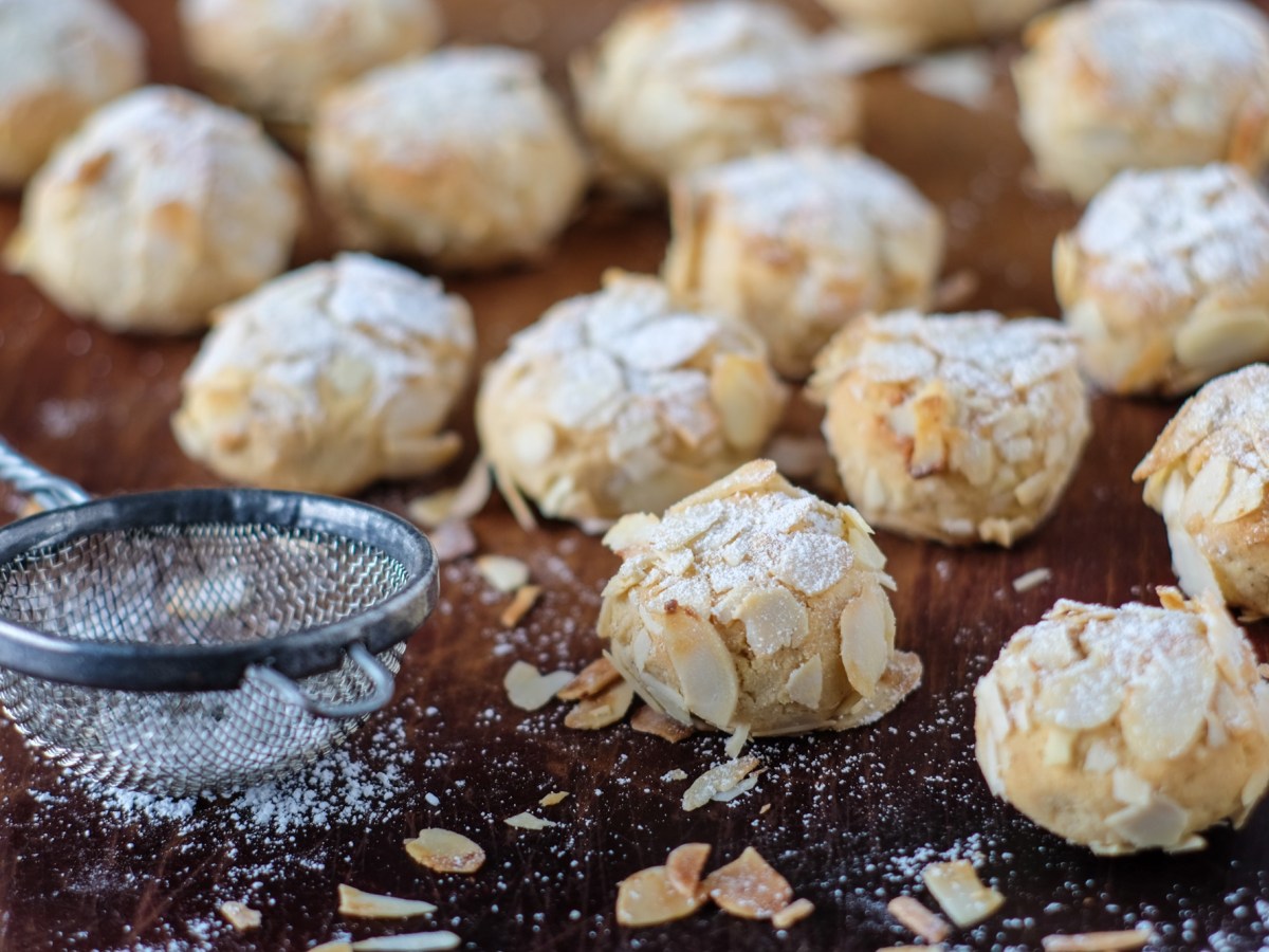 Marzipan-Mandorlini auf einem Tisch, Sieb daneben